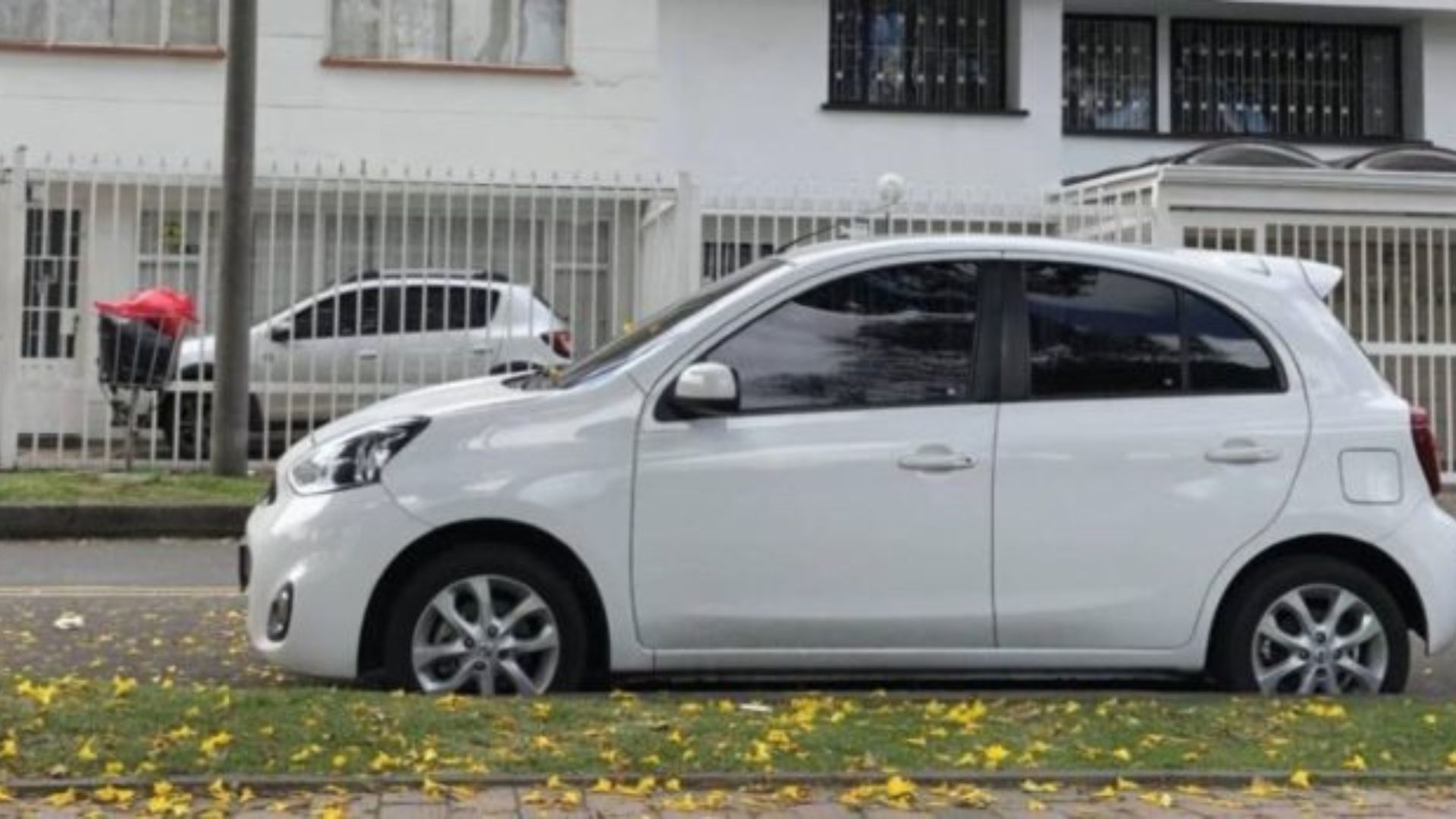 Automóvil blanco parqueado en una acera