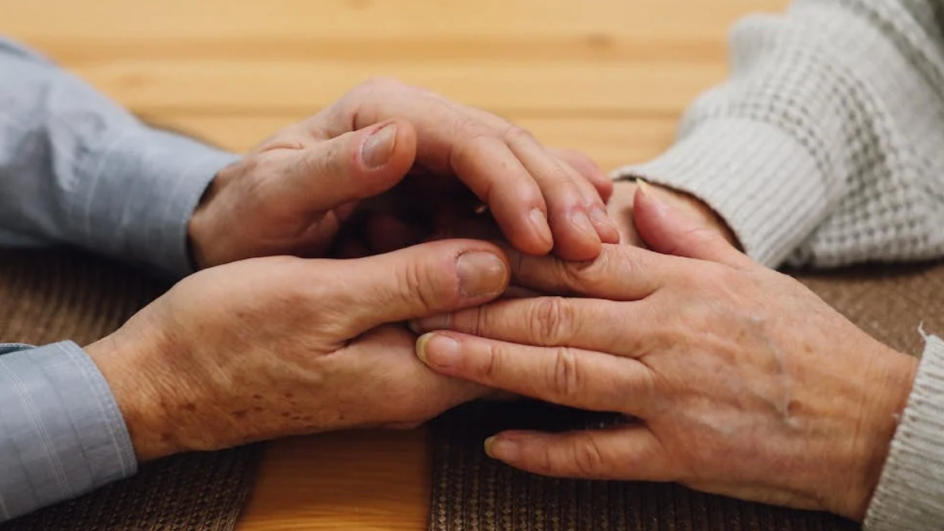 Las manos entrelazadas de dos personas mayores