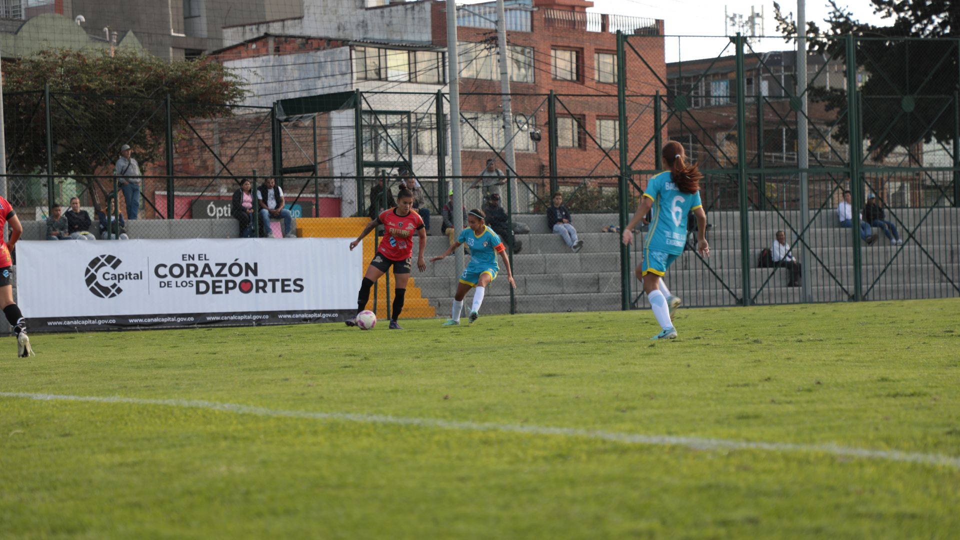 Dos mujeres con uniformes de fútbol disputando un balón