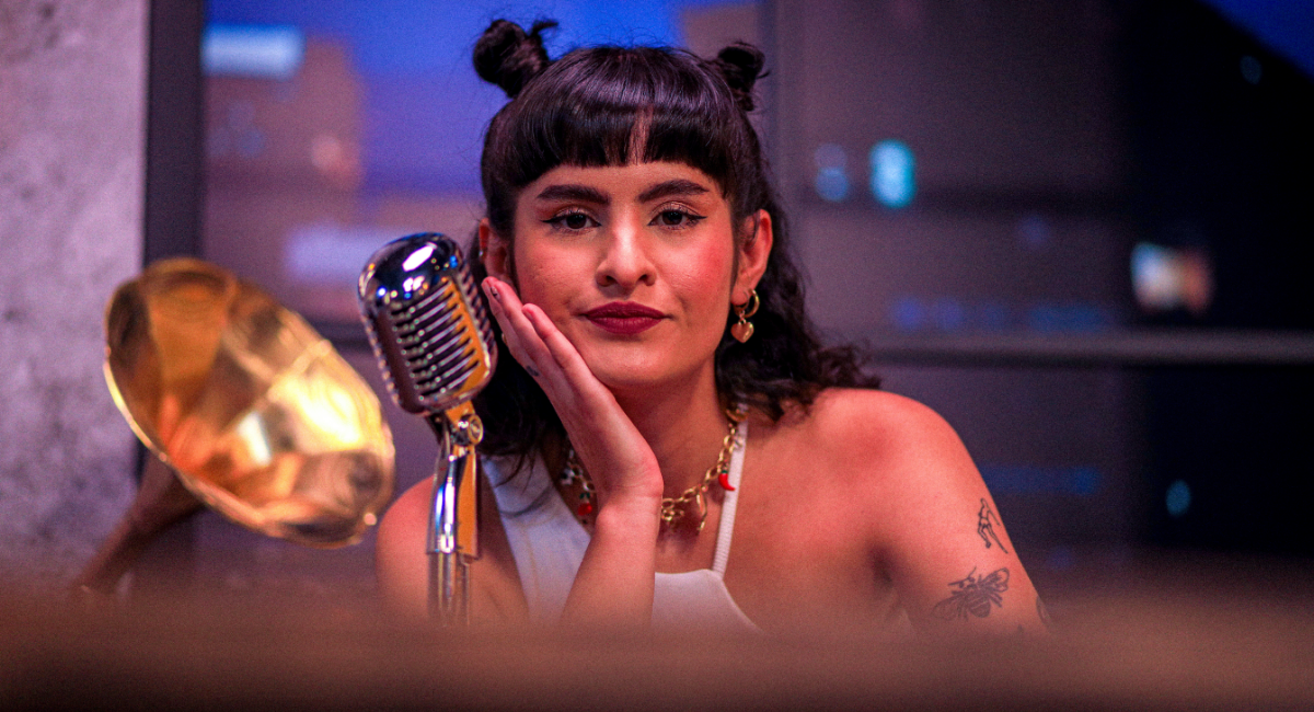 Fotografía de Mange, vestida de blanco y con un microfono.