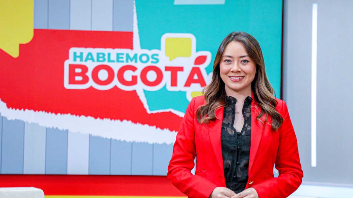 Yuri Paola Rodríguez Meneses, periodista, vestida de camisa negra y blazer rojo, con los brazos cruzados en el set de Hablemos Bogotá.