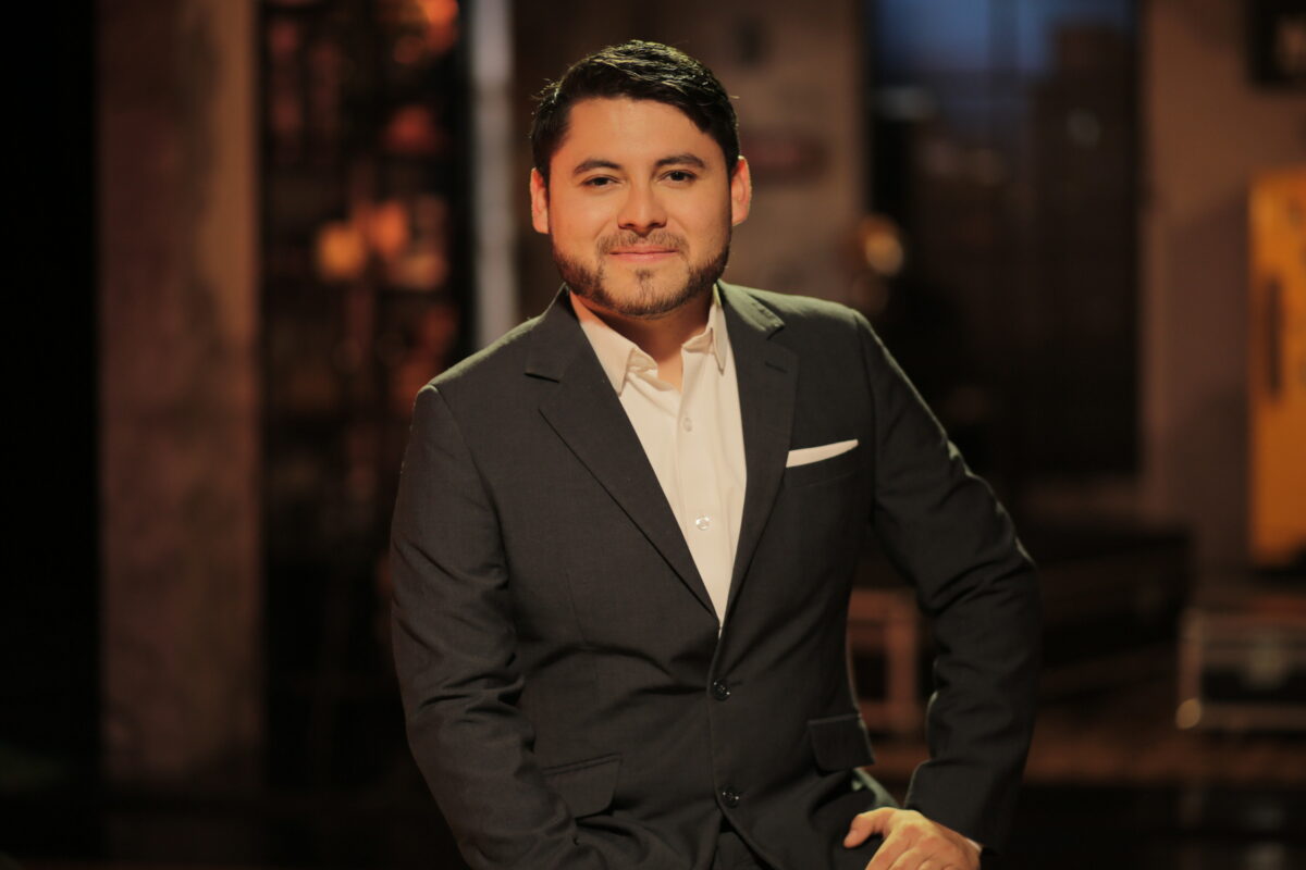 Cristian León, periodista de AHORA,  vestido de trabje negro y camisa blanca.