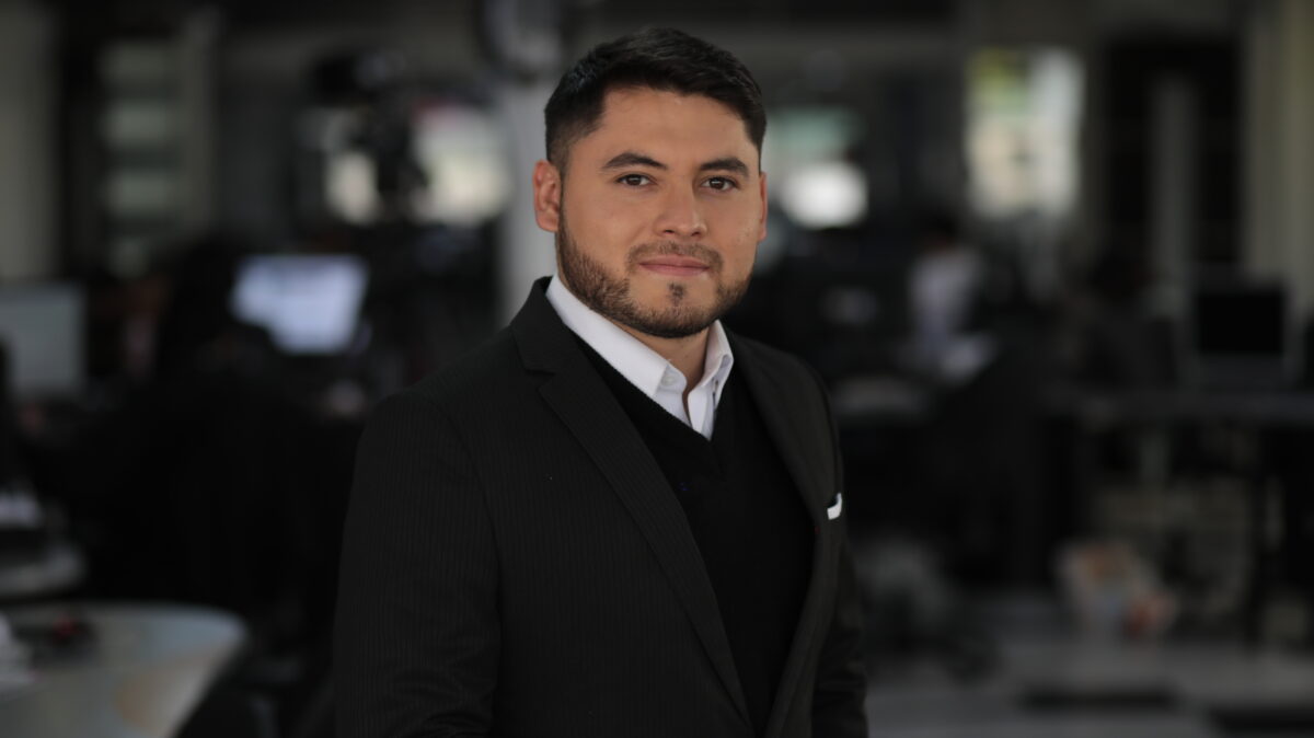 Cristian León, periodista de AHORA,  vestido de trabje negro,  saco negro y camisa blanca.