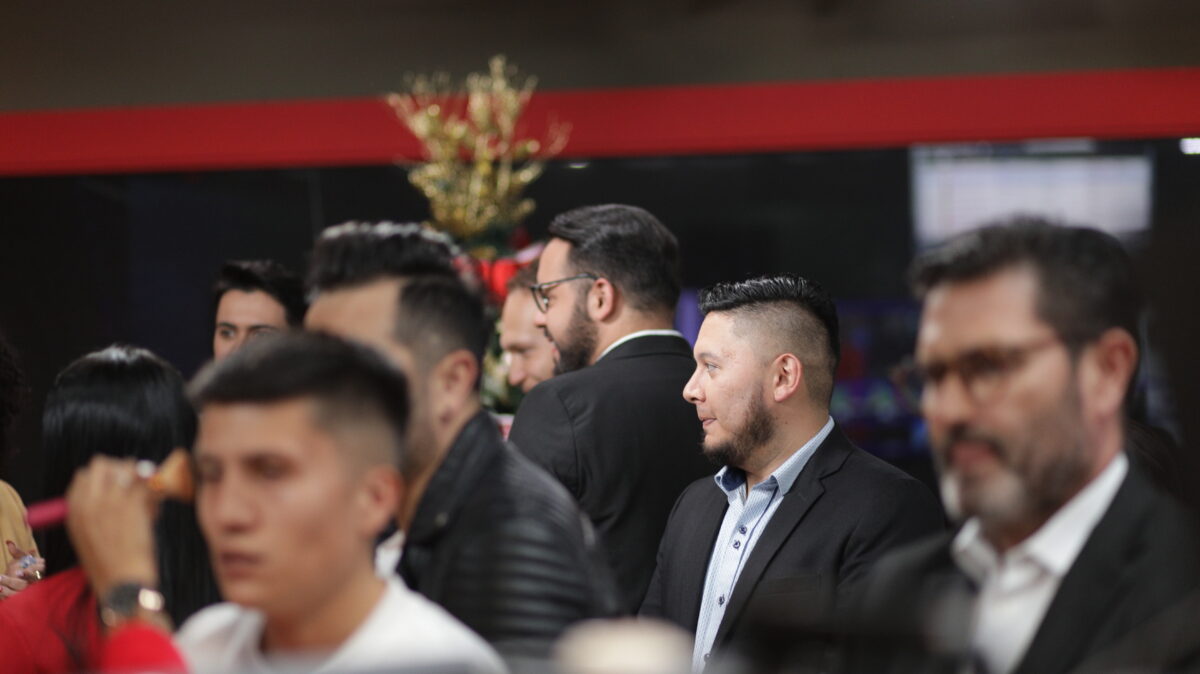Alexander Vera, periodista de AHORA, vestido con traje negro, camisa azul y en el set de AHORA junto con Juan Ossa, Alexandra, José Chinchilla, Miguel Porras y Duvan Rojas.