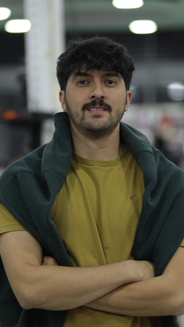 Foto de Camilo Jaramillo: hombre con pelo corto camiseta camel y saco. Además tiene sus brazos cruzados.